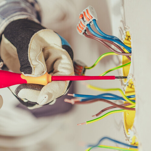 An electricain inspects commercial wiring.