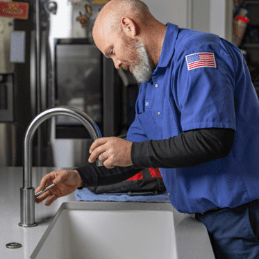 A plumber working on a sink.