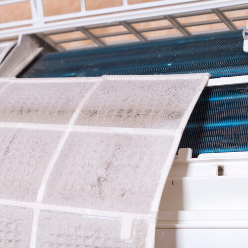 Dirty filter of air conditioner. Cleaning and washing maintenance. Removing dirty air-conditioner filter for washing.